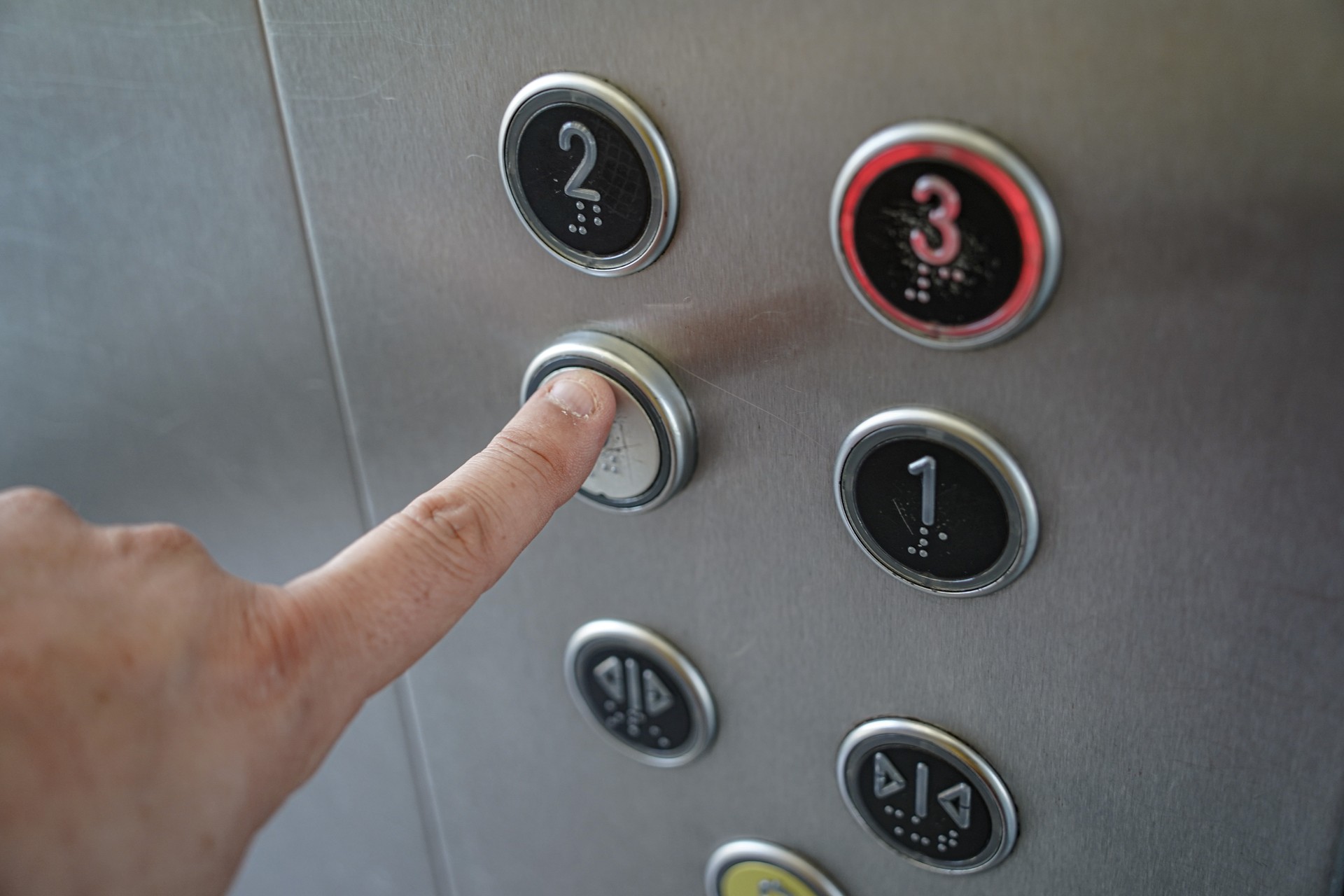 Finger pressing an elevator button